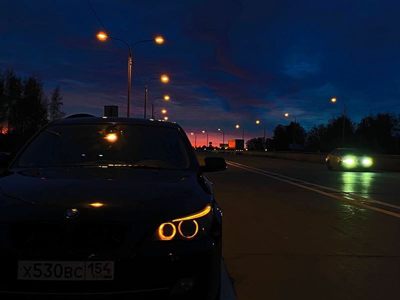 BMW на ночной трассе с включёнными огнями