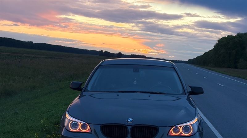 BMW на дороге на фоне закатного неба