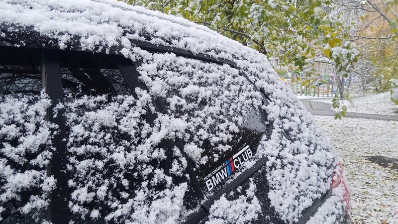 Заснеженная машина с клубным стикером BMW CLUB
